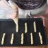 Pipe roughly 20 breadsticks onto a baking tray