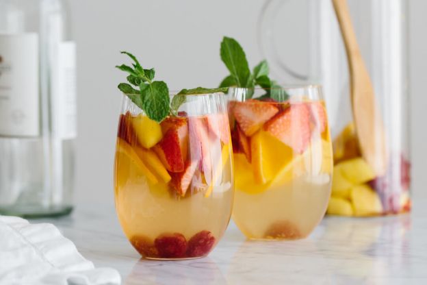 white sangria with mango and berries - © Downshiftology