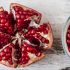 Remove pomegranate seeds using a wooden spoon