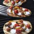 Grilled Pizzas with Sausage, Peppers, Roasted Tomatoes and Mozzarella