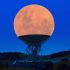 the moon over a radio telescope dish