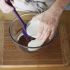 Pour 1/3 of the simmering cream mixture onto the melted chocolate and stir vigorously with a rubber spatula