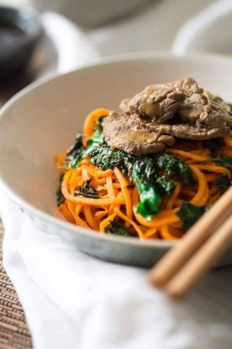 Paleo honey orange beef stir fry with sweet potato noodles and kale