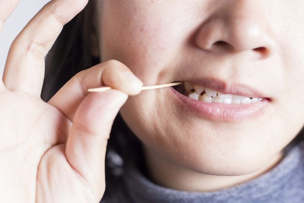 Picking at food in your teeth without a toothpick