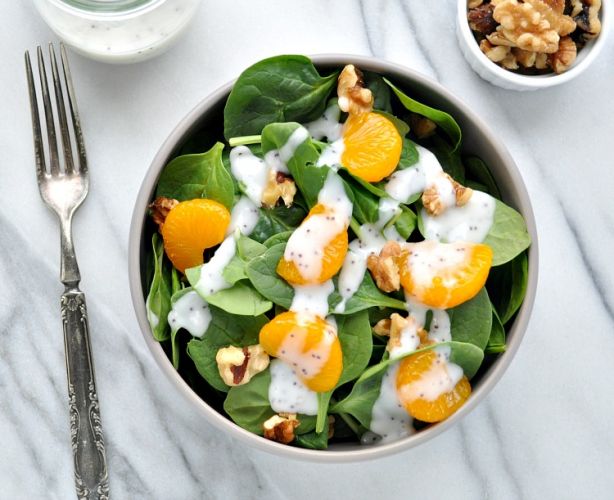 Fresh spinach salad with fruit and walnuts