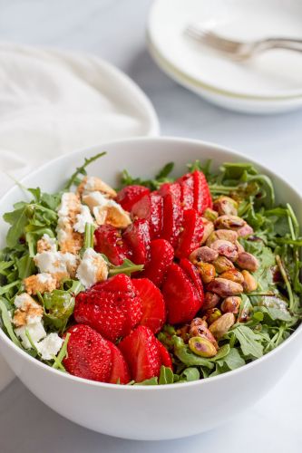 Arugula salad with strawberries, pistachios and goat cheese